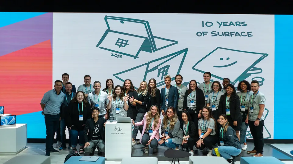 The event team gathered for a group photograph in front of a '10 Years of Surface' illustration.