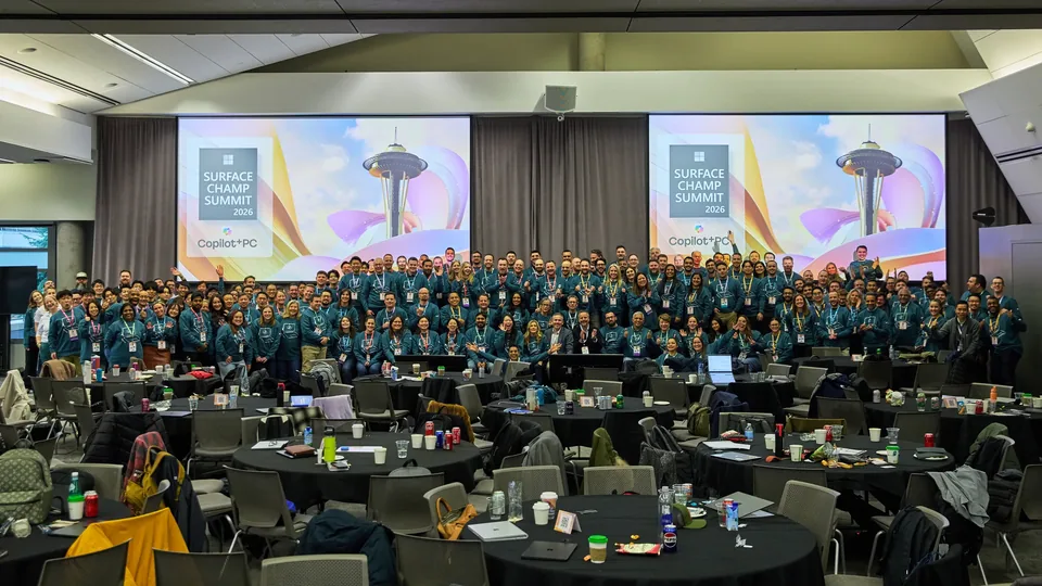 The full delegation gathered for a group photograph, screens behind them reading Surface Champ Summit 2026.